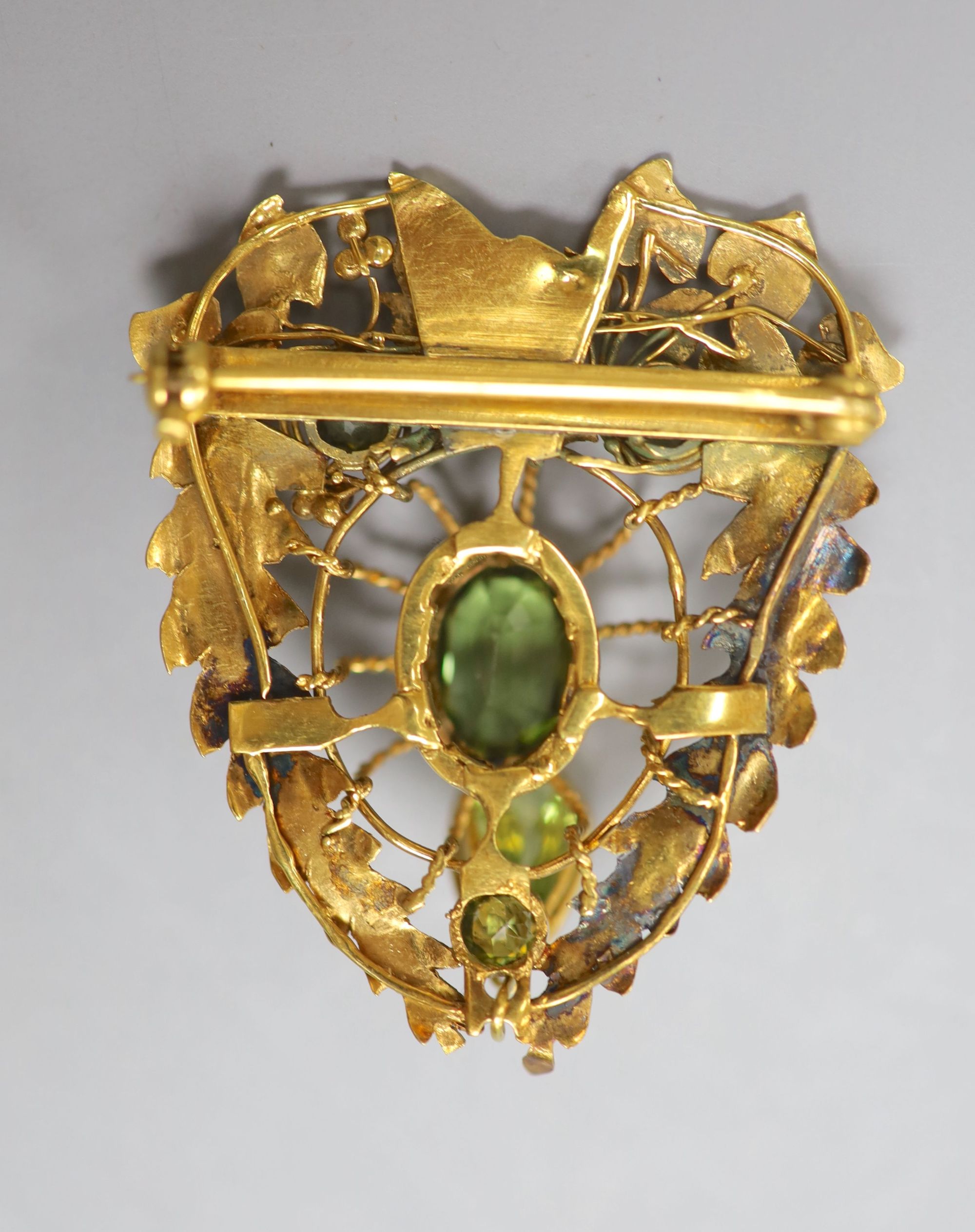 A pierced yellow metal and four stone peridot set brooch(adapted), 52mm, gross 9.7 grams.